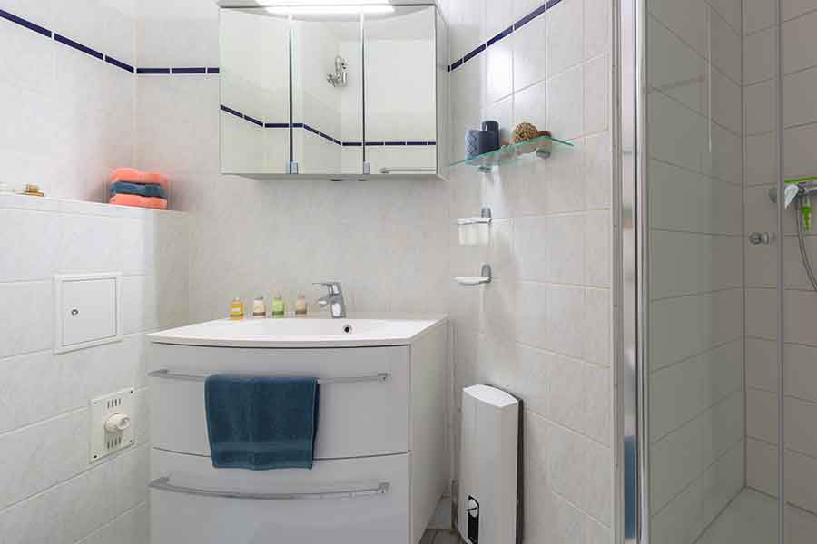 Badezimmer mit Toilette, Waschbecken und Spiegelschrank